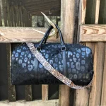 Side view of leopard print travel duffel showing 54L capacity depth for weekend travel